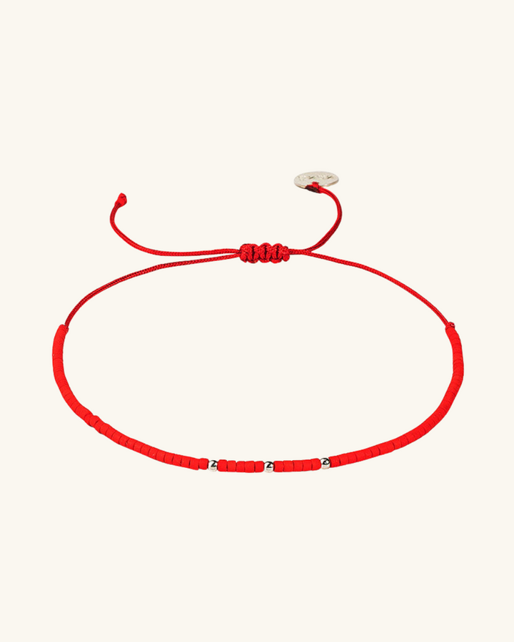 Pulsera roja con mostacillas de plata